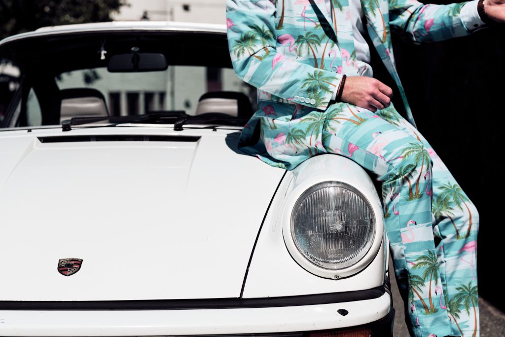 en man sitter på bilen som brudparet ska åka med